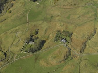 Oblique aerial view centred on the church and burial ground with the remains of the crofting township and field-system adjacent, taken from the S.
