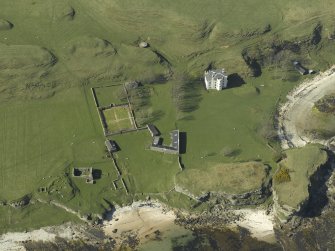 Oblique aerial view centred on the house and farmsteading and the remains of the church, burial-ground and cottage, taken from the SSE.