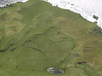 Oblique aerial view centred on the remains of the field-system and rig, taken from the NE.