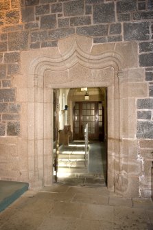 Interior. View of doorway in E side chapel leading to priest's house (door open)