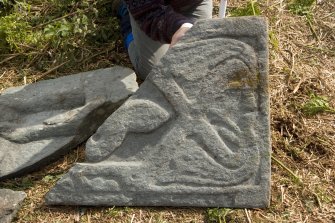 Fragment of west highland grave slab showing head of figur and decoration