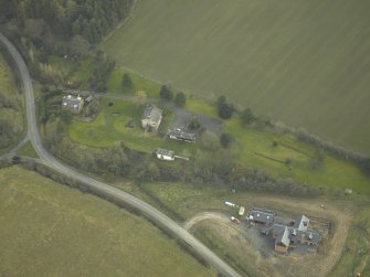 Oblique aerial view centred on the former Belses railway station buildings with the station masters house, the up and down platforms shelters and the remains of the goods platform adjacent, taken from NW.