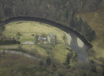 Oblique aerial view centred on the Castle/Tower-House and the outbuildings, gateway and part of walled garden, taken from the N.