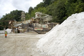 View of Eagle screw and flotation plant and raw sand stock awaiting crushing. The raw stock to the left of the picture has just been extracted from the mine.