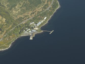 Oblique aerial view centred on the pier and buildings of the Royal Navy Torpedo Station, taken from the SSW.