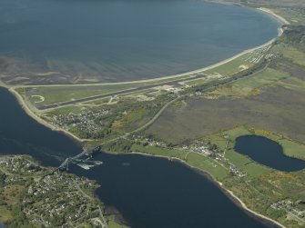 General oblique aerial view looking across the bridge, airfield,  village, the Falls of Lora and an 'SNP' banner, taken from the SSW.