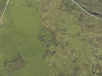 Oblique aerial view centred on the remains of the cairn and township, taken from the NNE.