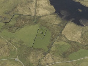 Oblique aerial view centred on the remains of the church and the burial ground, taken from the E.