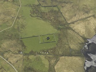 Oblique aerial view centred on the remains of the church and the burial ground, taken from the NE.