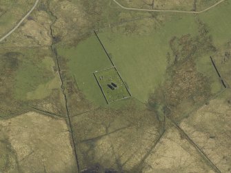 Oblique aerial view centred on the remains of the church and the burial ground, taken from the NW.