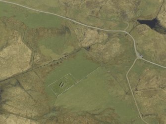 Oblique aerial view centred on the remains of the church and the burial ground, taken from the WSW.