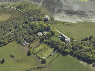 Oblique aerial view centred on the towerhouse, country house, walled garden and farmsteading, taken from the NNE.