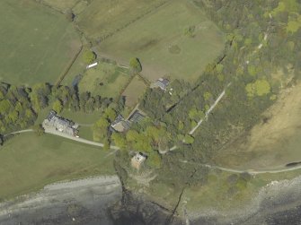 Oblique aerial view centred on the towerhouse, country house, walled garden and farmsteading, taken from the SSW.