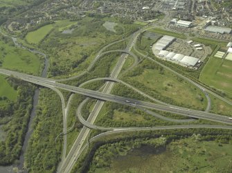 Oblique aerial view centred on the motorway interchange, taken from the NE.