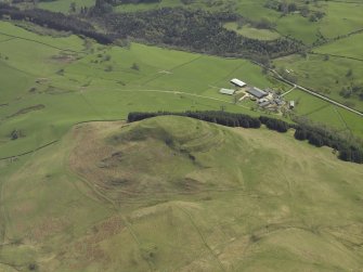 Oblique aerial view centred on the remains of the hillfort, taken from the NW.
