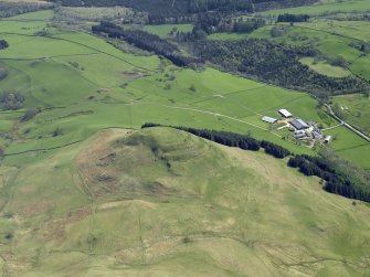 Oblique aerial view centred on the remains of the hillfort, taken from the NW.