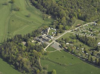 Oblique aerial view centred on the country house with the caravan park adjacent, taken from the NW.
