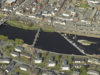 Oblique aerial view centred on the road bridge and weir, taken from the SW.