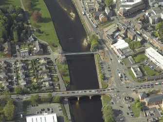 Oblique aerial view centred on the road bridge and suspension bridge, taken from the SE.