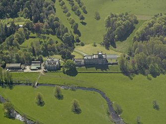 Oblique aerial view centred on the house with stable block and farm adjacent, taken from the N.