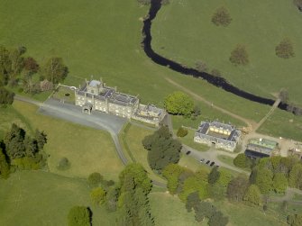 Oblique aerial view centred on the house with stable block and farm adjacent, taken from the SSE.