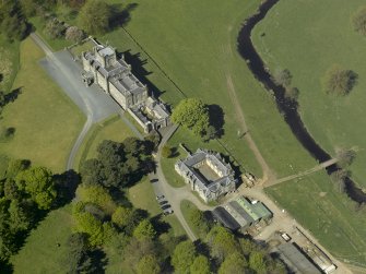 Oblique aerial view centred on the house with stable block and farm adjacent, taken from the SE.