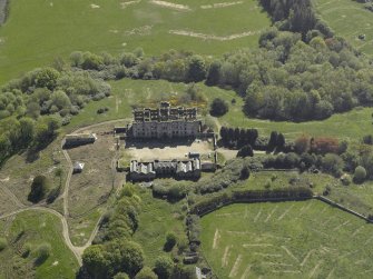 Oblique aerial view centred on the ruins of the country house, taken from the NW.