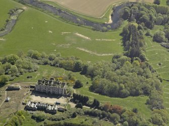 Oblique aerial view centred on the ruins of the country house, taken from the NW.