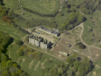 Oblique aerial view centred on the ruins of the country house, taken from the ENE.