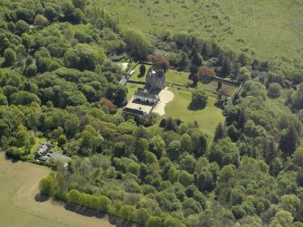 Oblique aerial view centred on the castle and country house,  taken from the NW.