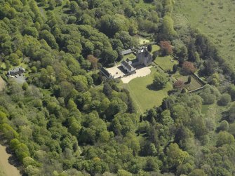 Oblique aerial view centred on the castle and country house,  taken from the NW.