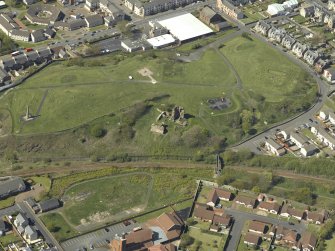 Oblique aerial view centre on the remains of Ardrossan Castle with the Monument adjacent, taken from the SE.