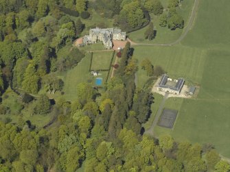 Oblique aerial view centred on the house with stable block adjacent, taken from the SW.