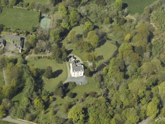 Oblique aerial view centred on the house with the walled garden adjacent, taken from the S.