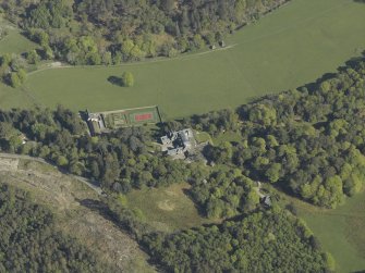 Oblique aerial view centred on the house with the gardener's cottage and walled garden adjacent, taken from the SSE.