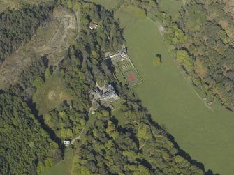 Oblique aerial view centred on the house with the gardener's cottage and walled garden adjacent, taken from the W.