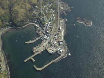 Oblique aerial view centred on the town and station with the harbour adjacent, taken from the N.