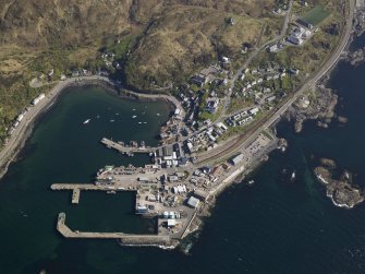 Oblique aerial view centred on the town and station with the harbour adjacent, taken from the NNW.