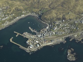 Oblique aerial view centred on the town and station with the harbour adjacent, taken from the NW.