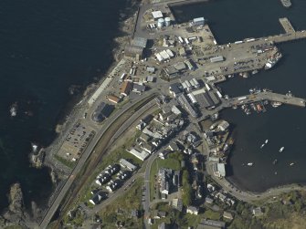 Oblique aerial view centred on the town and station with the harbour adjacent, taken from the SSW.