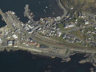 Oblique aerial view centred on the town and station with the harbour adjacent, taken from the WSW.