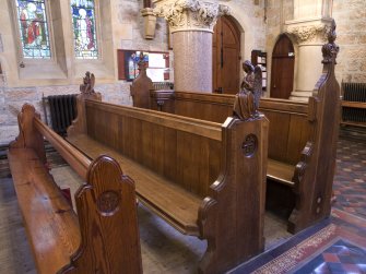 Interior. Detail of pew and carved former choir stalls