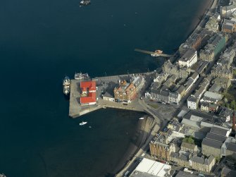 Oblique aerial view centred on the offices, pier and hotel, taken from the SW.