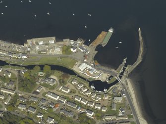 Oblique aerial view centred on the locks, canal basin, pier, harbour, lighthouse, church and buildings, taken from the WSW.