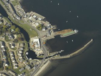 Oblique aerial view centred on the locks, canal basin, pier, harbour, lighthouse, church and buildings, taken from the SSW.