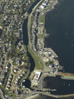 Oblique aerial view centred on the locks, canal basin, pier, harbour,  church and buildings, taken from the S.