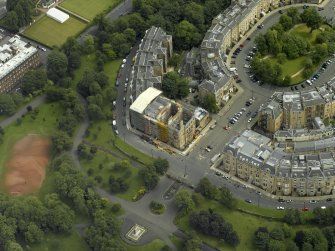 Oblique aerial view centred on the building with fire damaged flats under repair adjacent, taken from the W.