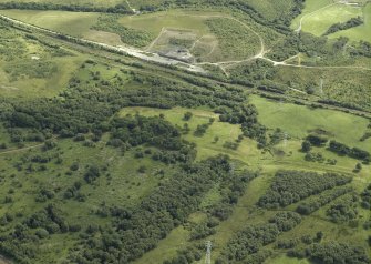 General oblique aerial view centred on the remains of the Roman fort and the course of the Antonine Wall, taken from the NNW.