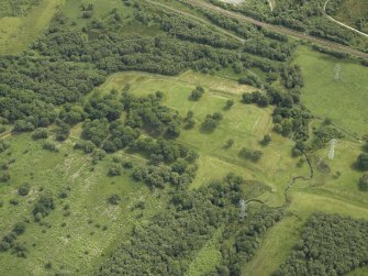 Oblique aerial view centred on the remains of the Roman fort and the course of the Antonine Wall, taken from the SE.