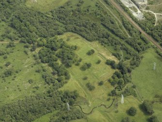 Oblique aerial view centred on the remains of the Roman fort and the course of the Antonine Wall, taken from the SSE.